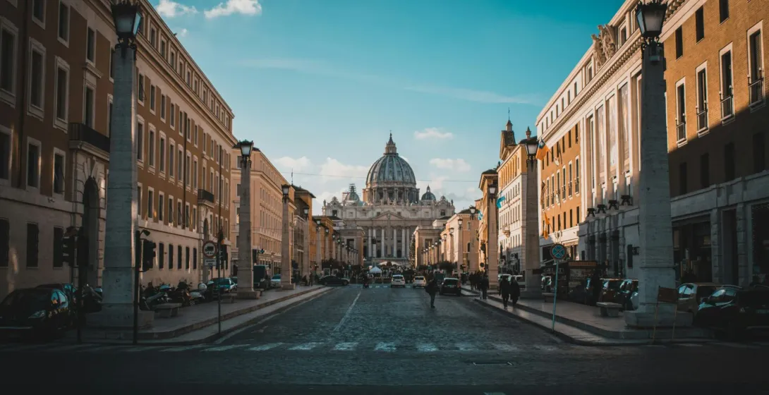 View of St. Peter's Basilica in Rome from a cobblestone street.