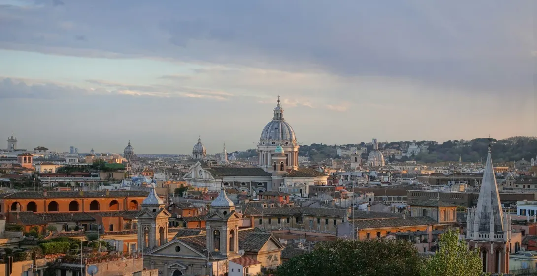 Sunset view of Rome's cityscape, featuring iconic domes and spires.