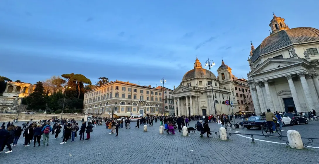 Tourists gather in Rome's Piazza del Popolo at sunset.