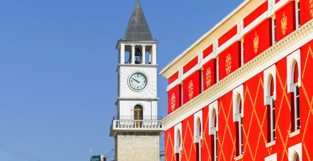 Tirana's Clock Tower and a vibrant building in the historic center.