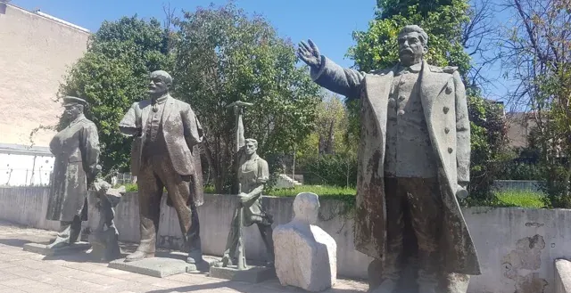 Weathered statues of communist leaders in a Tirana park.