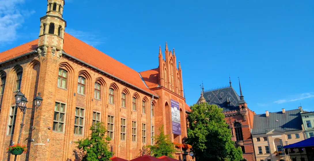 Tourists exploring the Old Town Hall in Toruń, Poland.