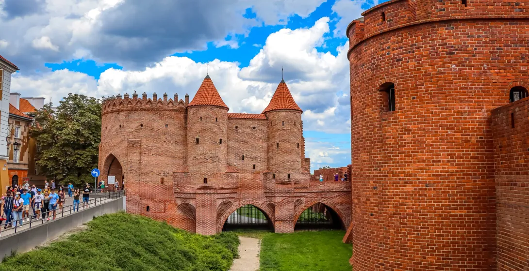 Tourists explore the historic Warsaw Barbican.