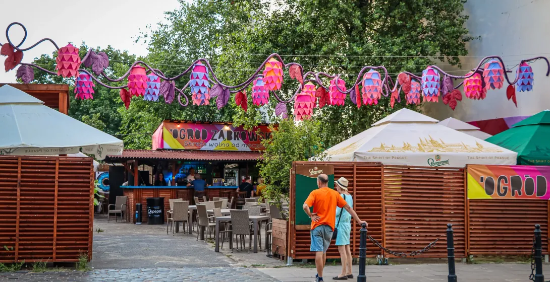 Tourists enjoying the vibrant atmosphere of Ogród Żabkowski in Warsaw, Poland.