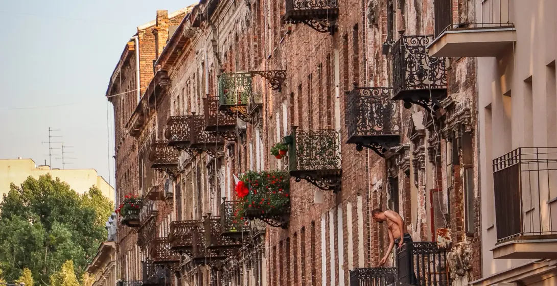 Historic buildings with ornate balconies line a Warsaw street.