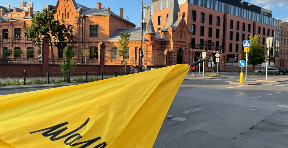 Yellow Mokka umbrella in Warsaw, Poland, showcasing historical and modern architecture.