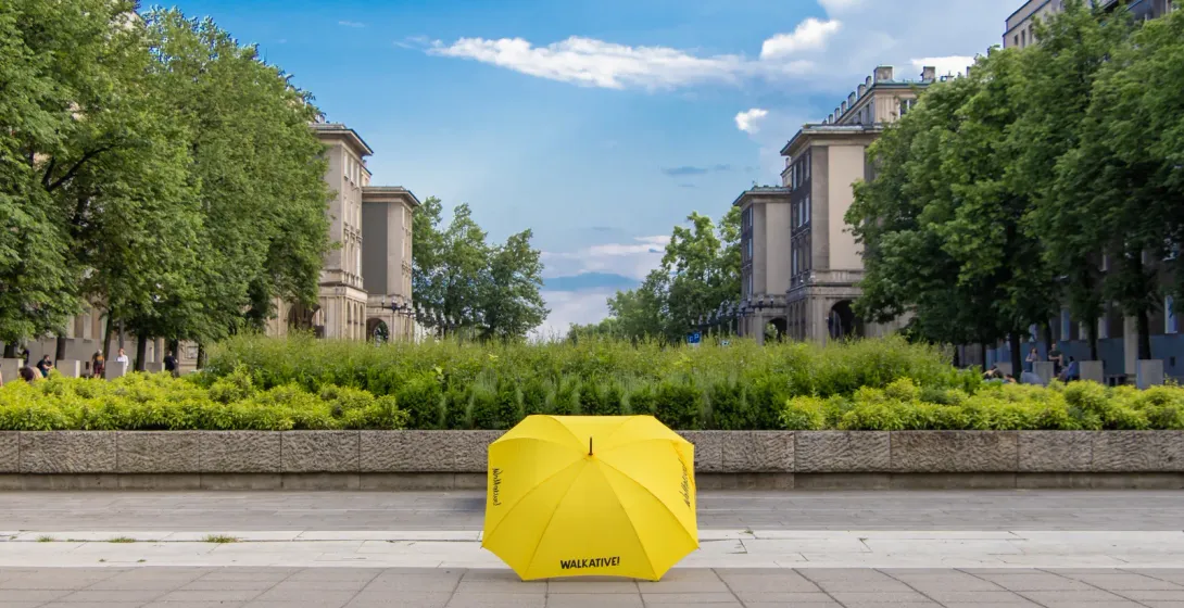 Yellow umbrella on a city street, inviting you to join a Walkative tour.