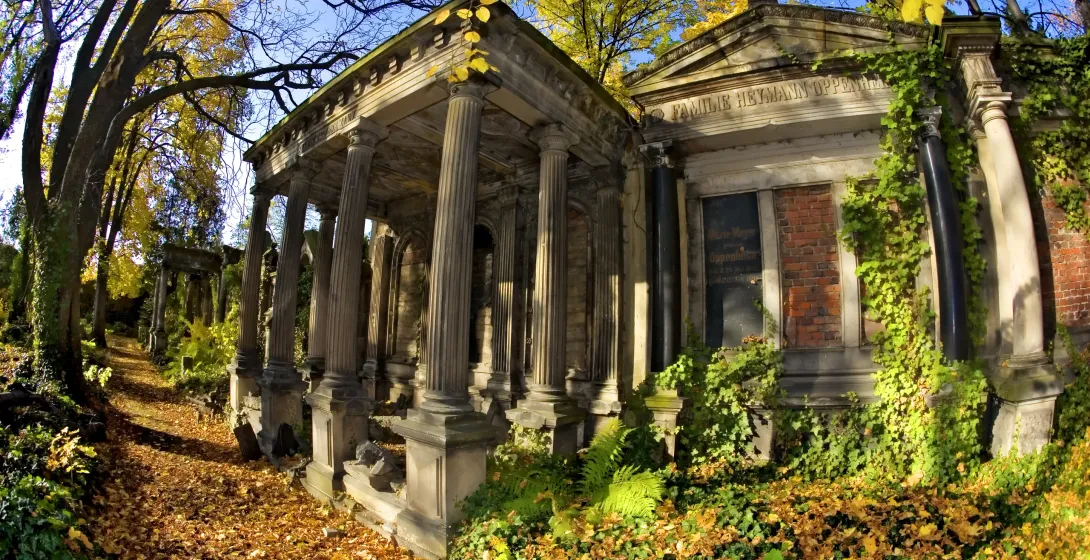Autumnal scene in Wroclaw's historic cemetery, featuring a grand mausoleum.