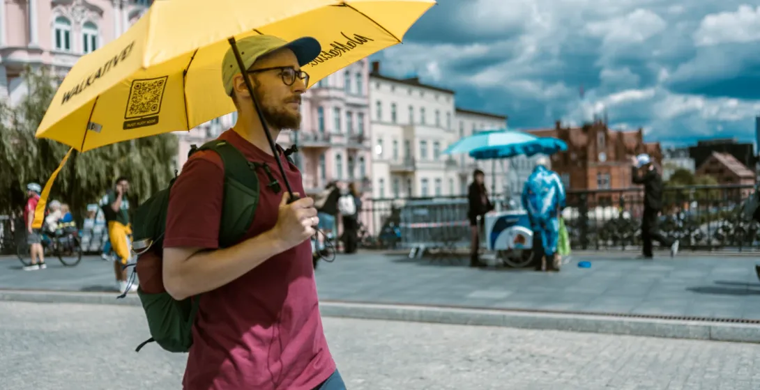 A Walkative guide with the characteristic yellow umbrella.