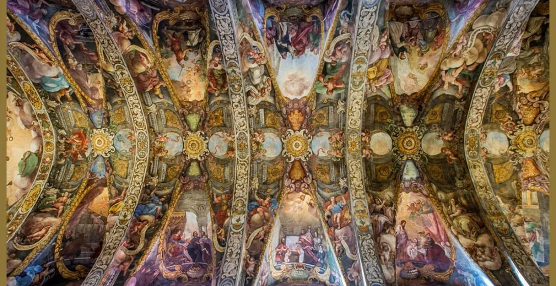 The ornate, frescoed vaulted ceilings of the Church of San Nicolás in Valencia, depicting religious scenes.