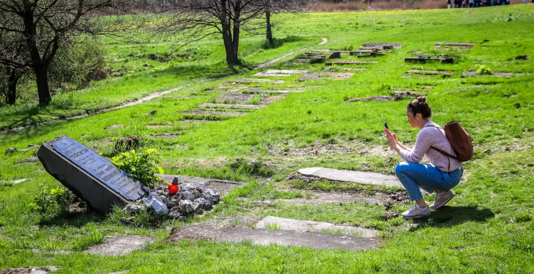 Tourist taking a photo at the Płaszów memorial in Krakow, Poland.