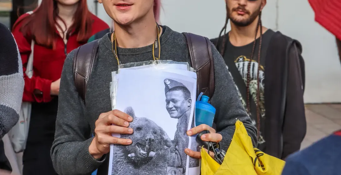 A tour guide shows a group a historical photo of a Polish soldier with Wojtek the Bear during a walking tour in Krakow.
