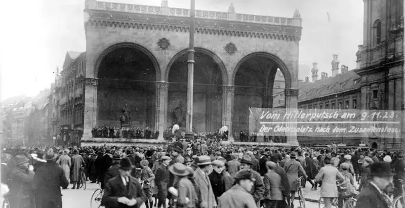 Black and white historical photo of a large crowd gathered in front of the Feldherrnhalle at Odeonsplatz in Munich.