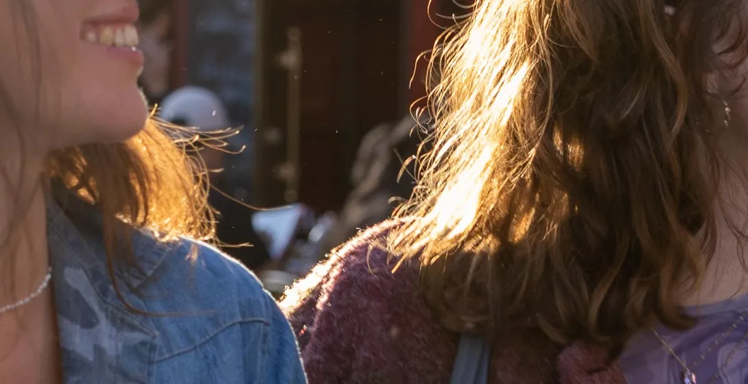 Two people with sunlit hair in front of La Mère Catherine restaurant in Montmartre, Paris.