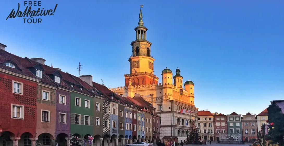 Poznań Old Town Hall with a tall clock tower, surrounded by colorful historic merchant houses under a clear blue sky.