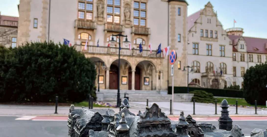 Bronze architectural model of old town buildings in the foreground, with the grand Collegium Minus of Adam Mickiewicz Univ...