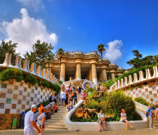 Tourists exploring the vibrant mosaic architecture of Park Güell in Barcelona.