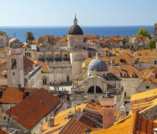 Aerial view of Dubrovnik's Old Town with terracotta roofs and the Adriatic Sea.
