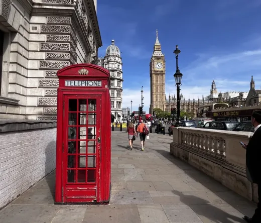 Iconic London scene: red phone booth, Big Ben, and Houses of Parliament.