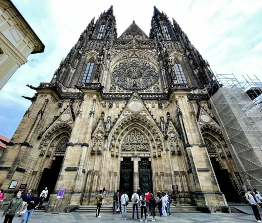 A tour group stands before the magnificent St. Vitus Cathedral in Prague Castle.