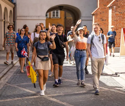 Happy tourists on a guided walking tour in Warsaw's Old Town.