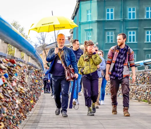 A Walkative tour group explores Krakow, Poland, walking across a bridge covered in love locks.