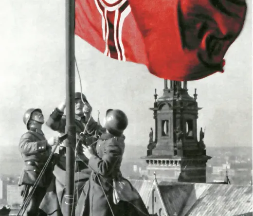 Soldiers raising a flag on a rooftop in Krakow.
