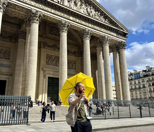 A tour guide leads a group through the Latin Quarter in Paris, showcasing the Panthéon.