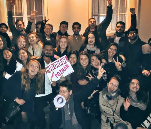 Duża grupa uczestniczy w pub crawl w Poznaniu, Polska.
