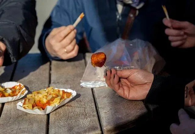 Tourists enjoying Currywurst in Berlin.