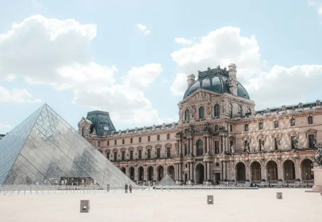 The Louvre Museum in Paris, featuring its iconic glass pyramid and classical architecture.