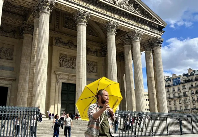 A tour guide leads a group through the Latin Quarter in Paris, showcasing the Panthéon.