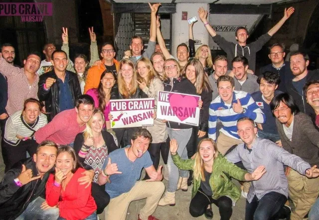 A large group of happy tourists on a pub crawl in Warsaw, Poland.