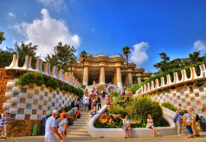 Tourists exploring the vibrant mosaic architecture of Park Güell in Barcelona.