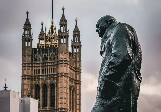 Statue of Winston Churchill with the Palace of Westminster in the background in London.