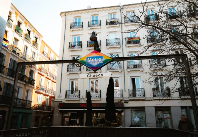 Madrid's Chueca neighborhood: A vibrant metro sign and colorful buildings.