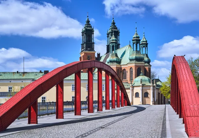 Red bridge in Poznan, Poland, with the Poznan Cathedral in the background.
