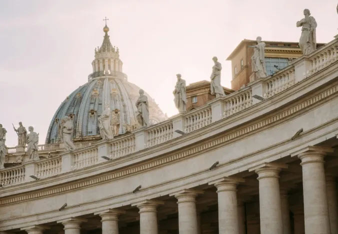 Statues and the dome of St. Peter's Basilica in Rome.