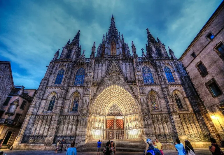 Barcelona Cathedral at dusk, tourists admiring the Gothic architecture.