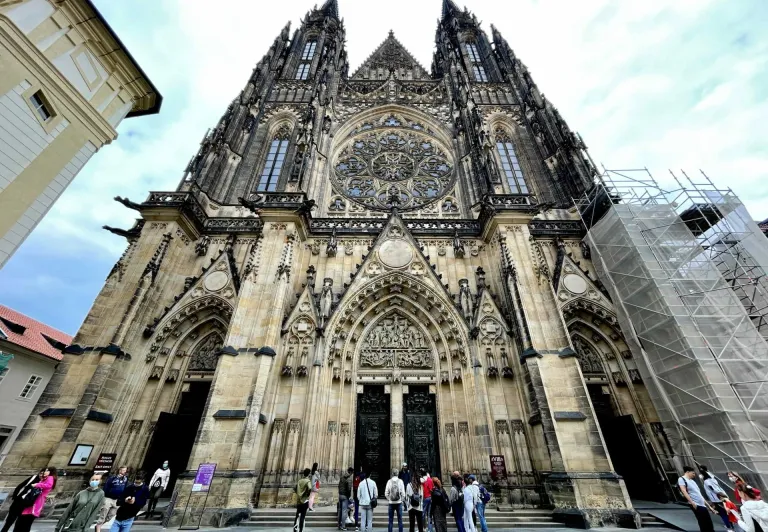 A tour group stands before the magnificent St. Vitus Cathedral in Prague Castle.