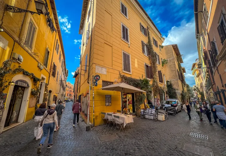 Tourists exploring the charming cobblestone streets of Trastevere, Rome.