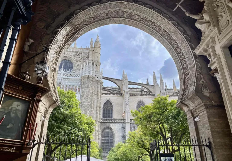 Stunning view of Seville Cathedral through an ornate archway.