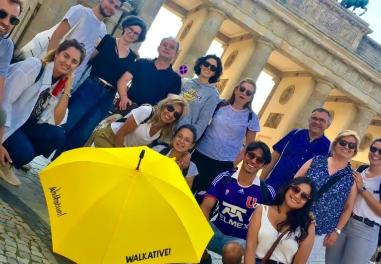 Happy tourists on a WALKATIVE! tour in front of Berlin's Brandenburg Gate.