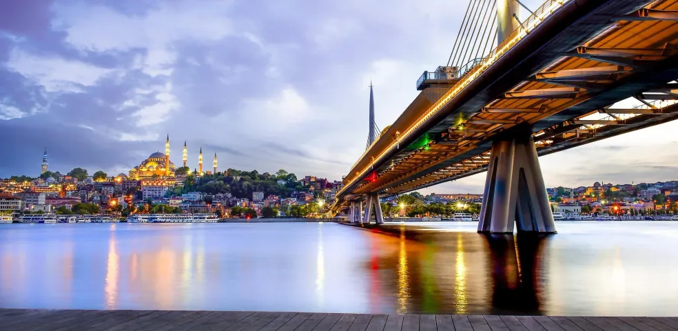 Istanbul cityscape with Halic Metro Bridge at dusk.