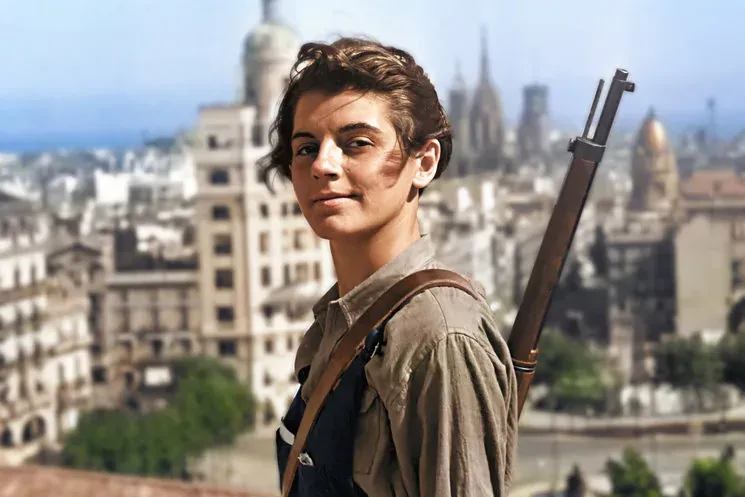 Young woman in period clothing with a rifle slung over her shoulder, on a rooftop overlooking the Barcelona cityscape.