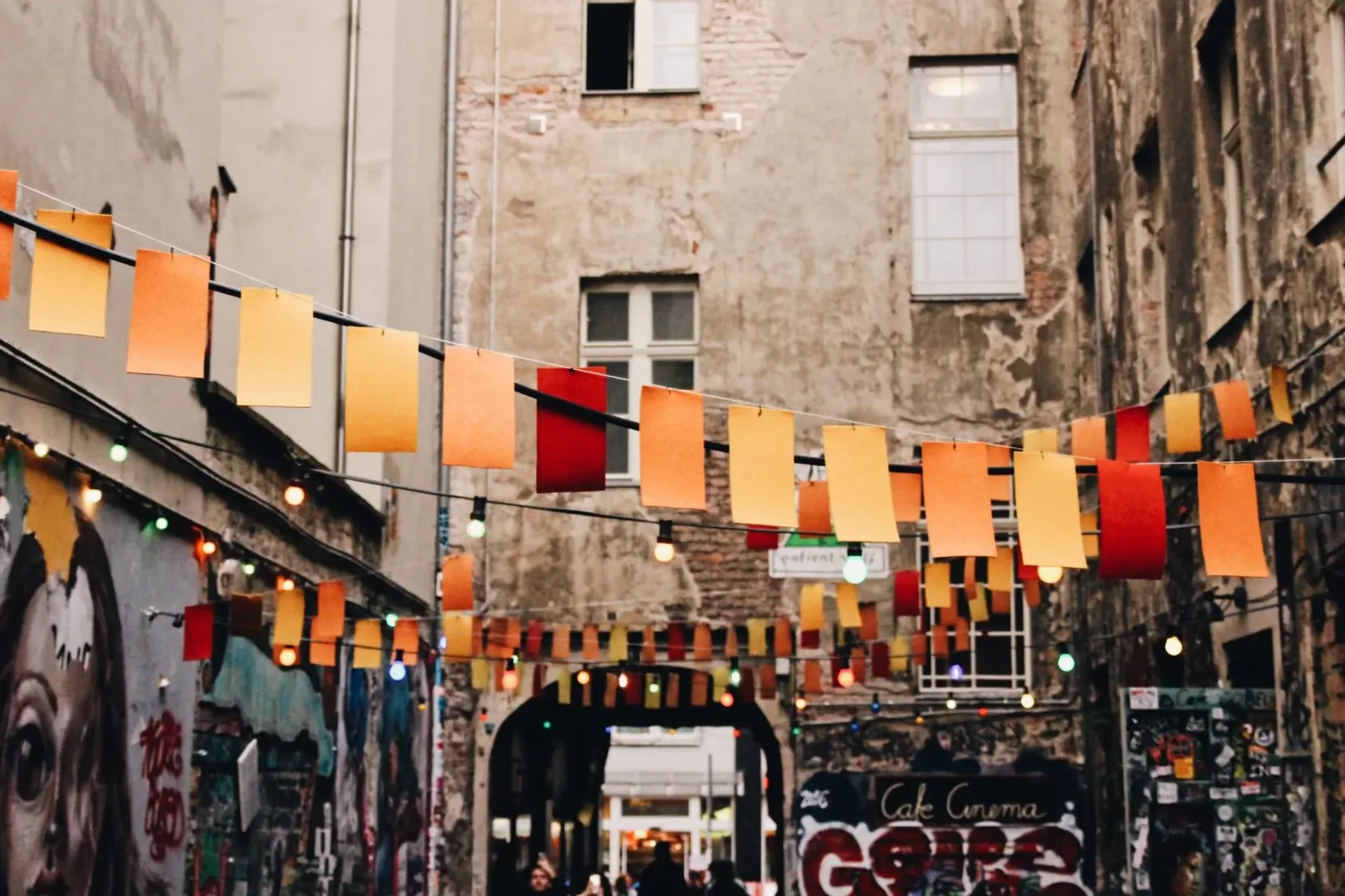 Colorful flags and string lights illuminate a charming Berlin alleyway.