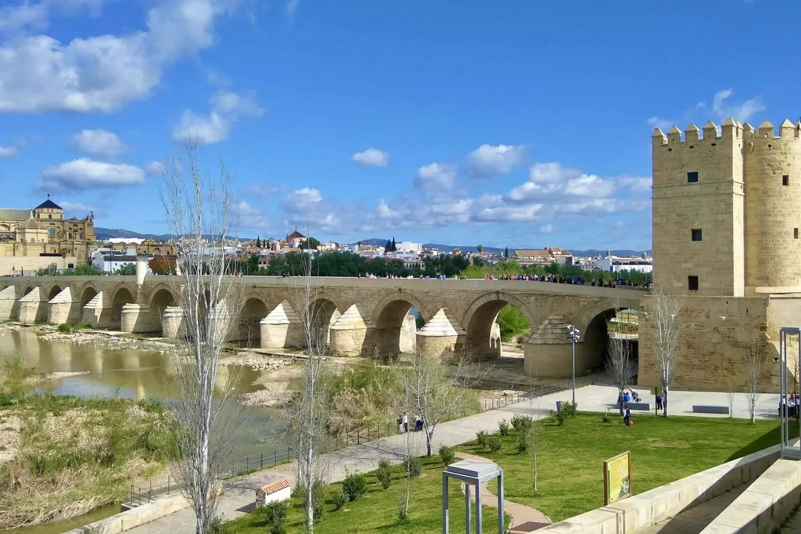 Roman Bridge over Guadalquivir River in Cordoba, with Calahorra Tower and Mezquita-Cathedral in the background under a blu...