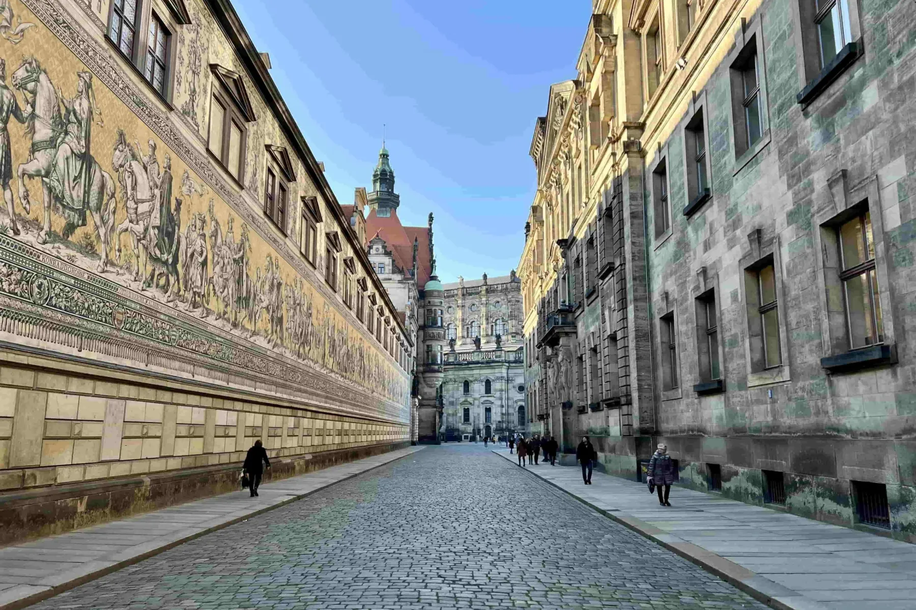 Tourists explore the Fürstenzug mural and Dresden Castle in Dresden, Germany.