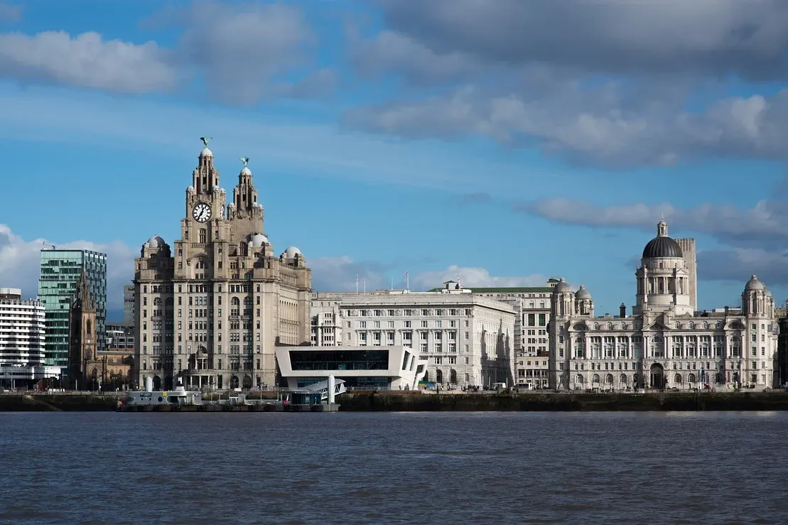 Liverpool waterfront with the Royal Liver Building, Cunard Building, and Port of Liverpool Building under a partly cloudy ...