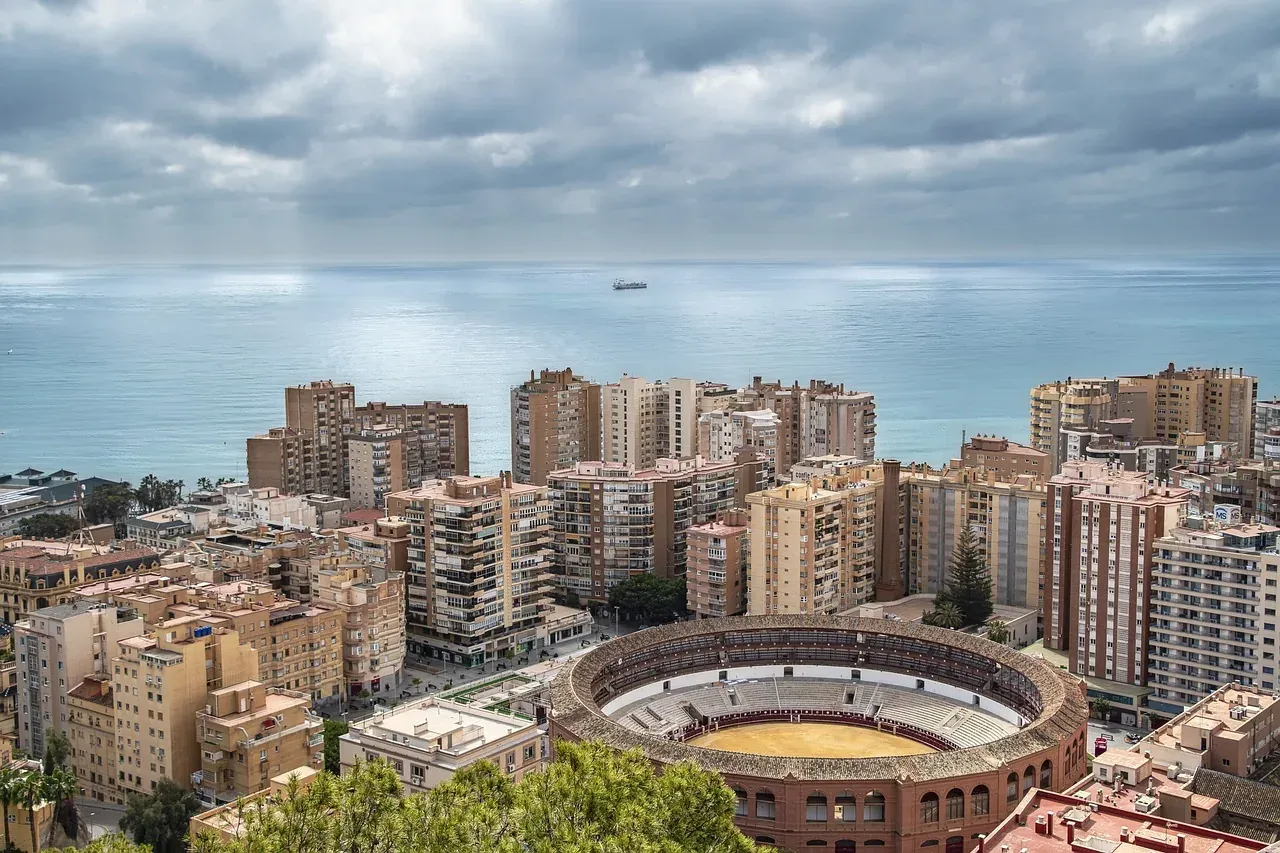 Aerial view of Malaga coastline with the Plaza de Toros bullring in the foreground, residential buildings, and the sea und...